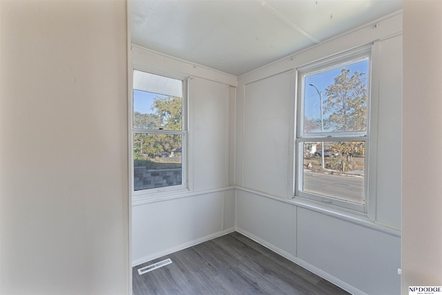 unfurnished room with plenty of natural light and dark wood-type flooring