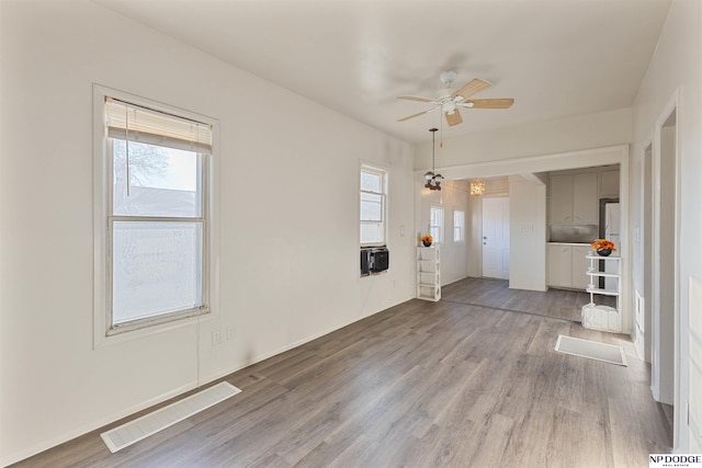 unfurnished living room featuring ceiling fan and light hardwood / wood-style floors