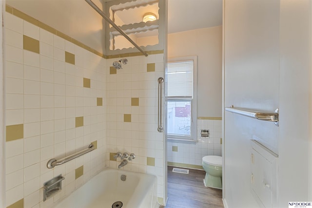 bathroom featuring hardwood / wood-style flooring, tile walls, and toilet