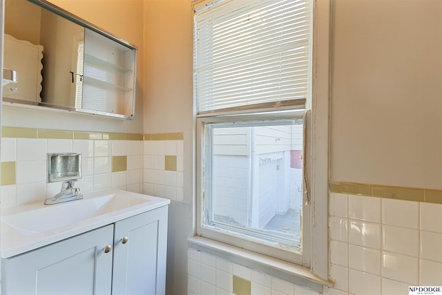 bathroom featuring vanity and tile walls