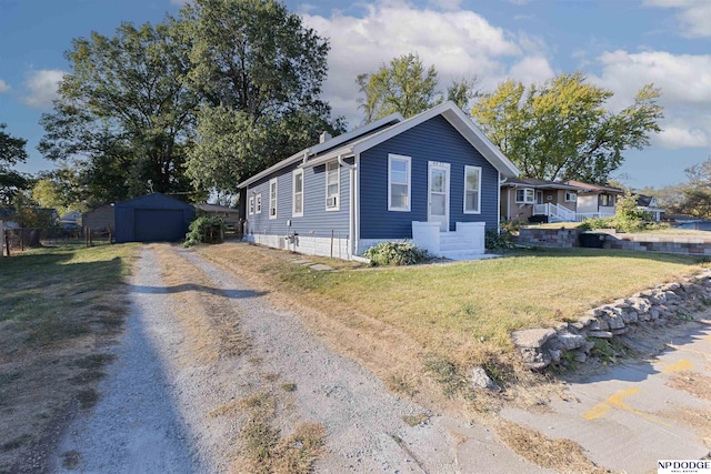 view of front of house featuring a front yard and a storage unit