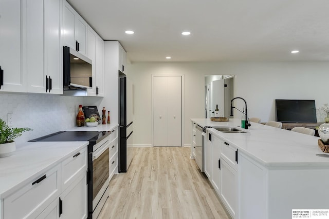 kitchen with white cabinetry, appliances with stainless steel finishes, and light stone counters