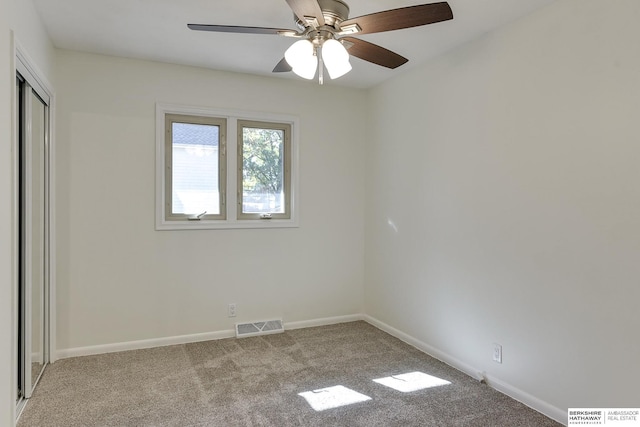 spare room featuring light carpet and ceiling fan