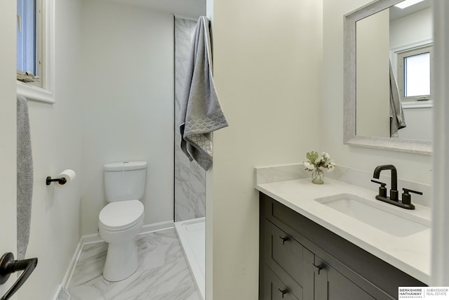 bathroom featuring vanity, toilet, and a shower