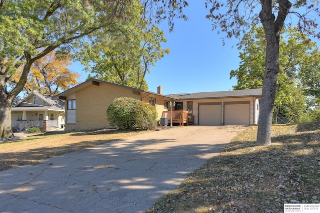 view of front of home with cooling unit, a garage, and covered porch