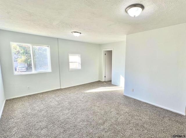 carpeted spare room with a textured ceiling