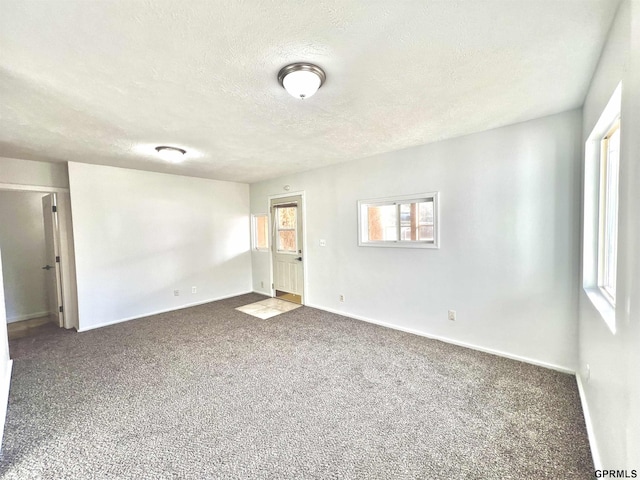 carpeted spare room with a textured ceiling