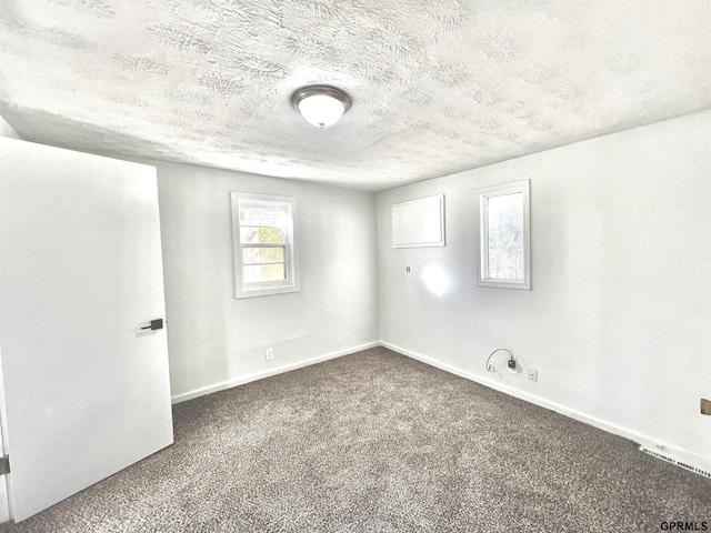 carpeted spare room featuring a textured ceiling