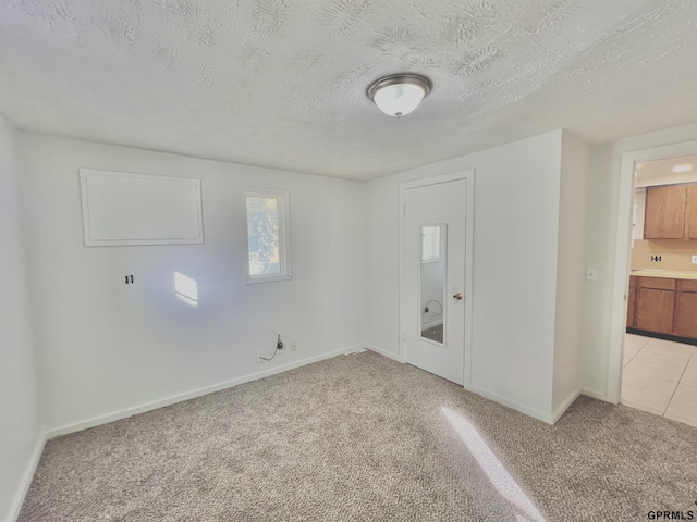 entrance foyer featuring light colored carpet and a textured ceiling