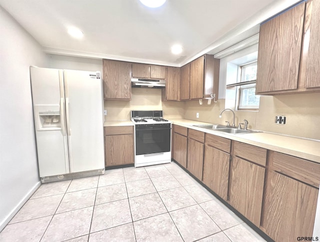 kitchen with white appliances, sink, and light tile patterned floors