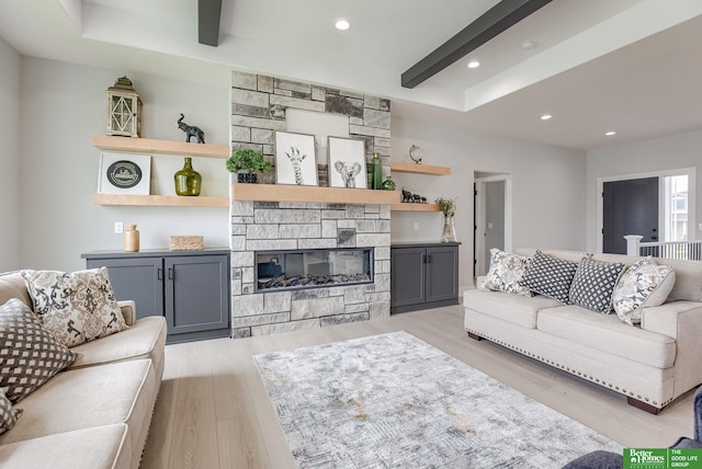 living room featuring a stone fireplace and light hardwood / wood-style flooring