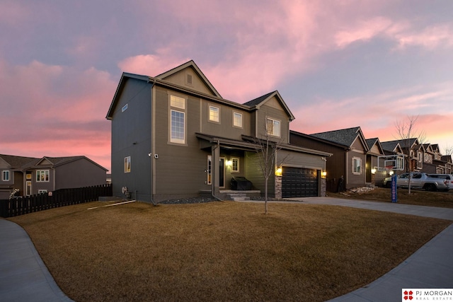 view of front of home featuring a garage and a yard