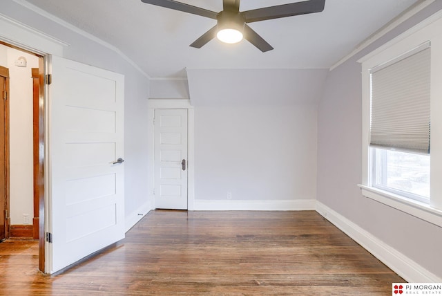 empty room with dark wood-type flooring, ceiling fan, lofted ceiling, and ornamental molding