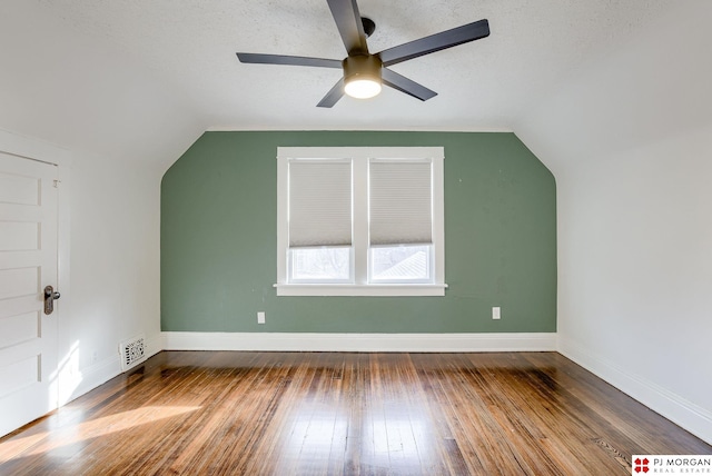 bonus room with ceiling fan, wood-type flooring, vaulted ceiling, and a textured ceiling