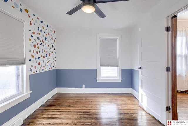 unfurnished room featuring ceiling fan, hardwood / wood-style floors, and a wealth of natural light