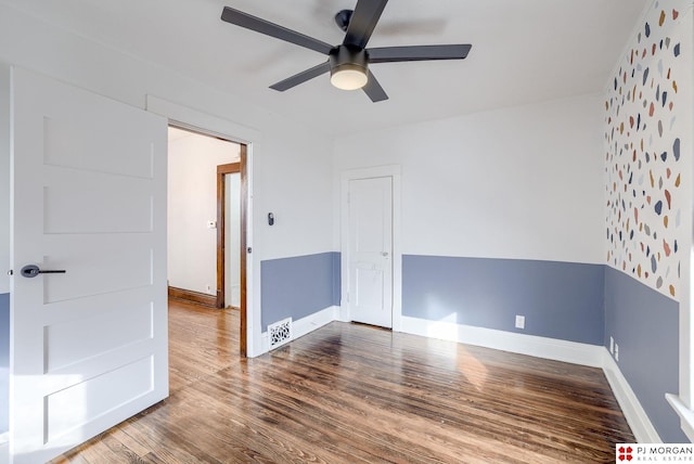 empty room with hardwood / wood-style floors and ceiling fan