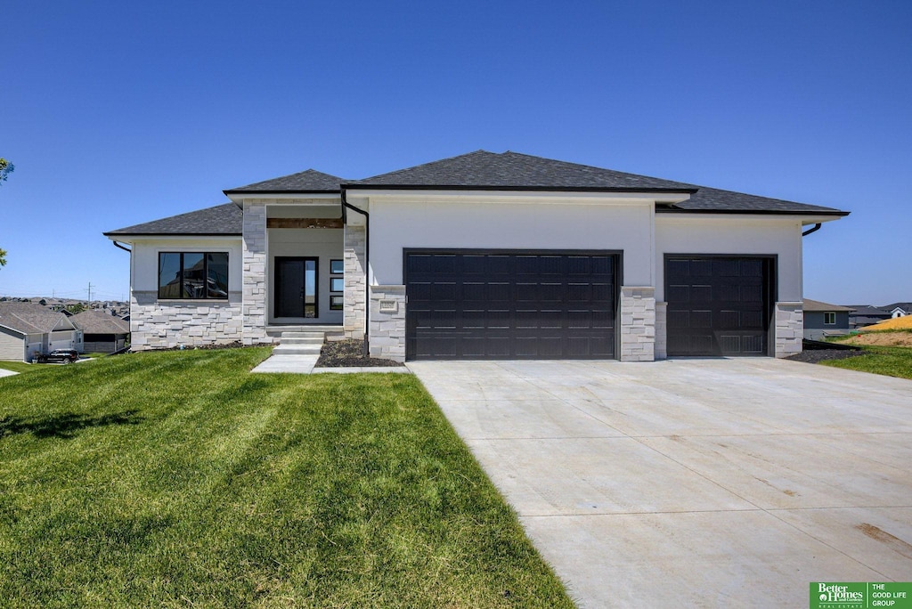 prairie-style house featuring a garage and a front yard