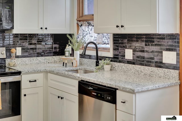 kitchen with stainless steel appliances, white cabinetry, sink, and decorative backsplash