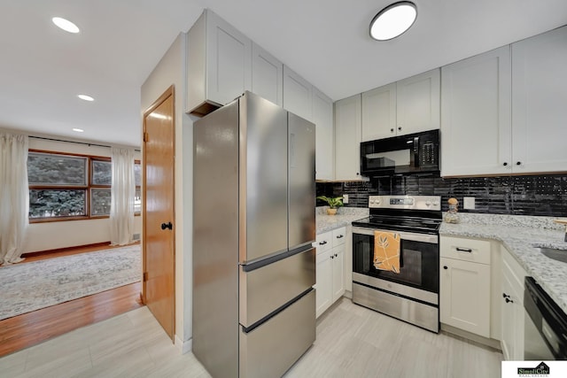 kitchen featuring light stone counters, white cabinetry, decorative backsplash, and appliances with stainless steel finishes