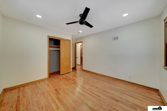 unfurnished bedroom with ceiling fan, a closet, and light wood-type flooring