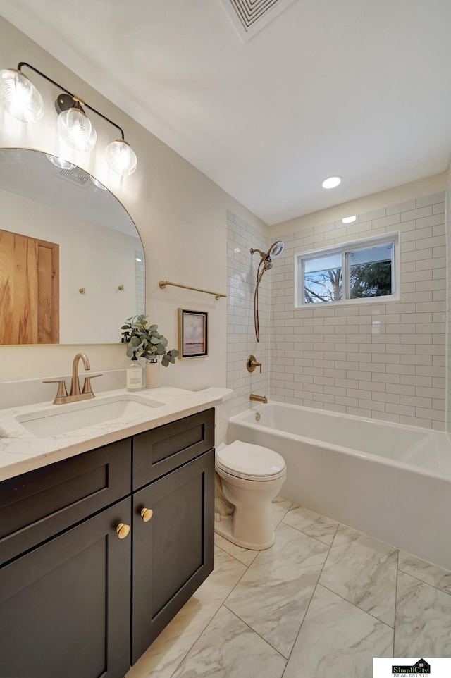 full bathroom with vanity, tiled shower / bath combo, and toilet