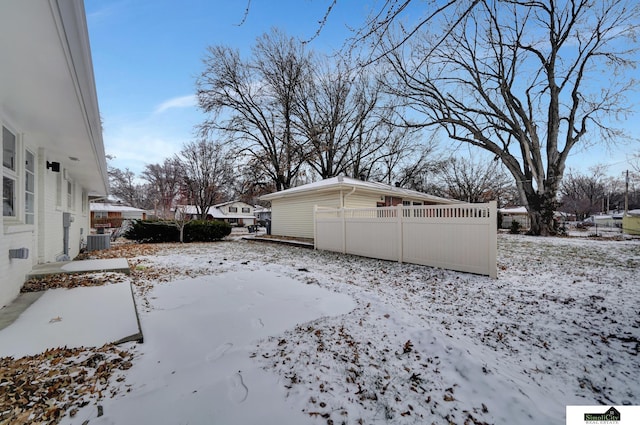 snow covered property with central air condition unit