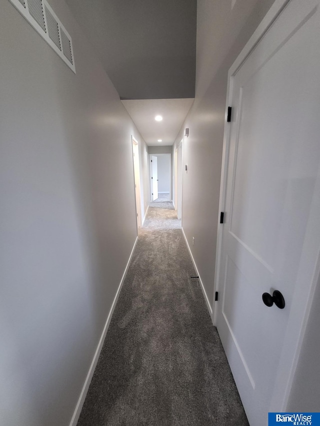 hallway featuring dark carpet