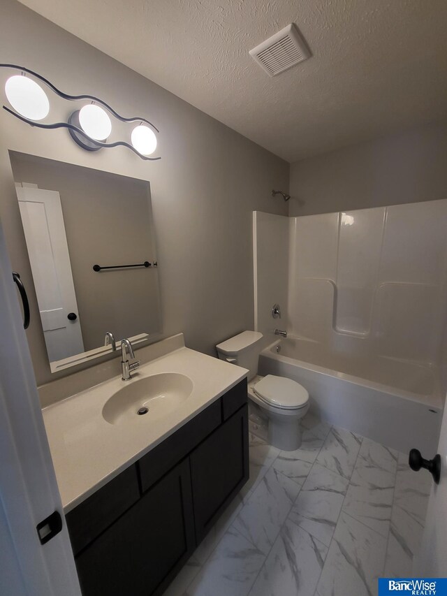 full bathroom featuring vanity, bathtub / shower combination, a textured ceiling, and toilet