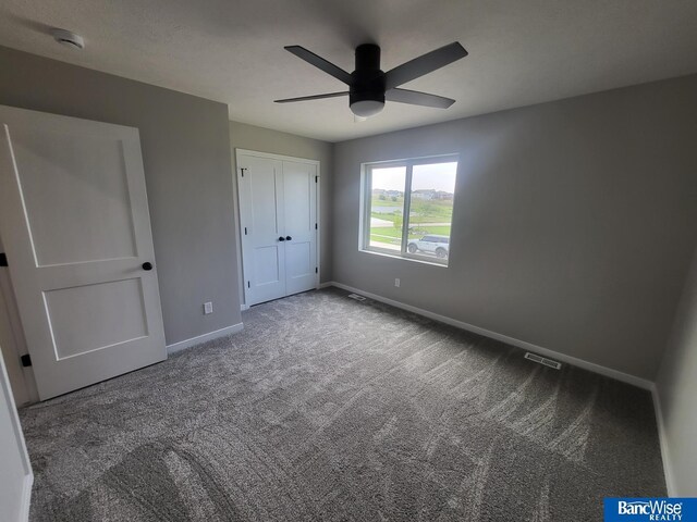 unfurnished bedroom with carpet floors, a closet, and ceiling fan