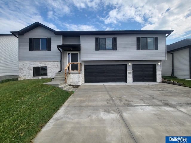 bi-level home featuring a garage and a front lawn