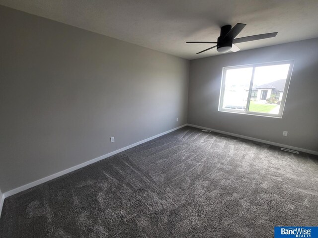 carpeted spare room featuring ceiling fan