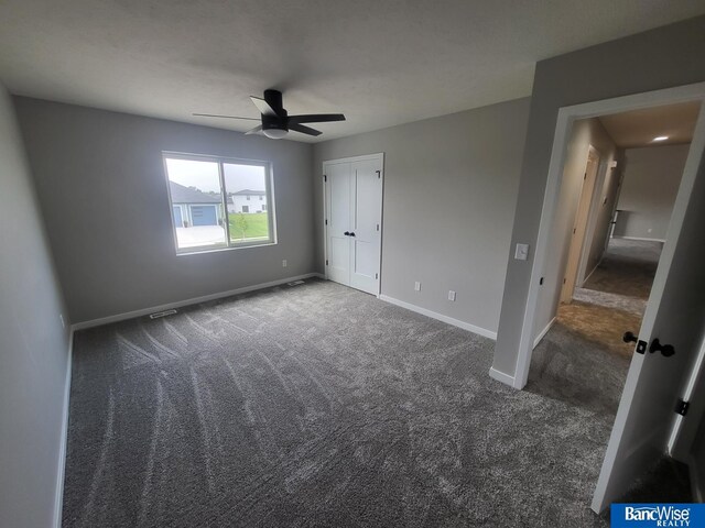 unfurnished bedroom featuring dark carpet and ceiling fan