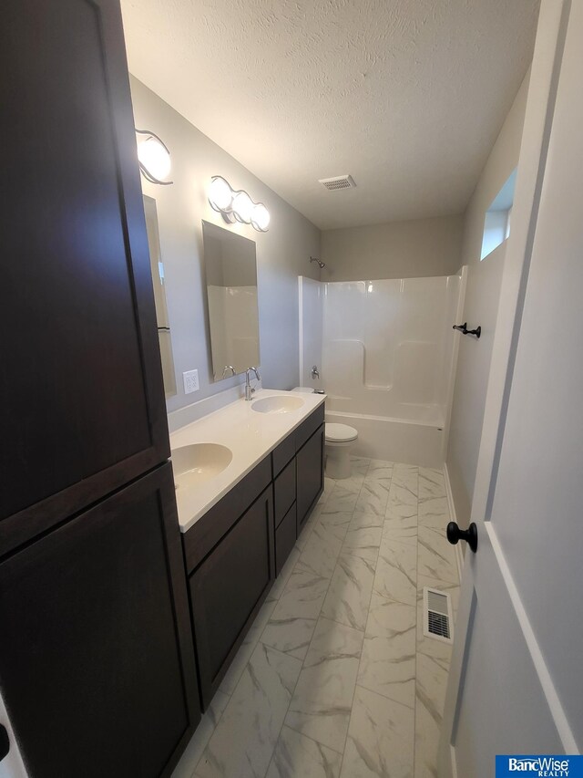 full bathroom with vanity, toilet, shower / bath combination, and a textured ceiling