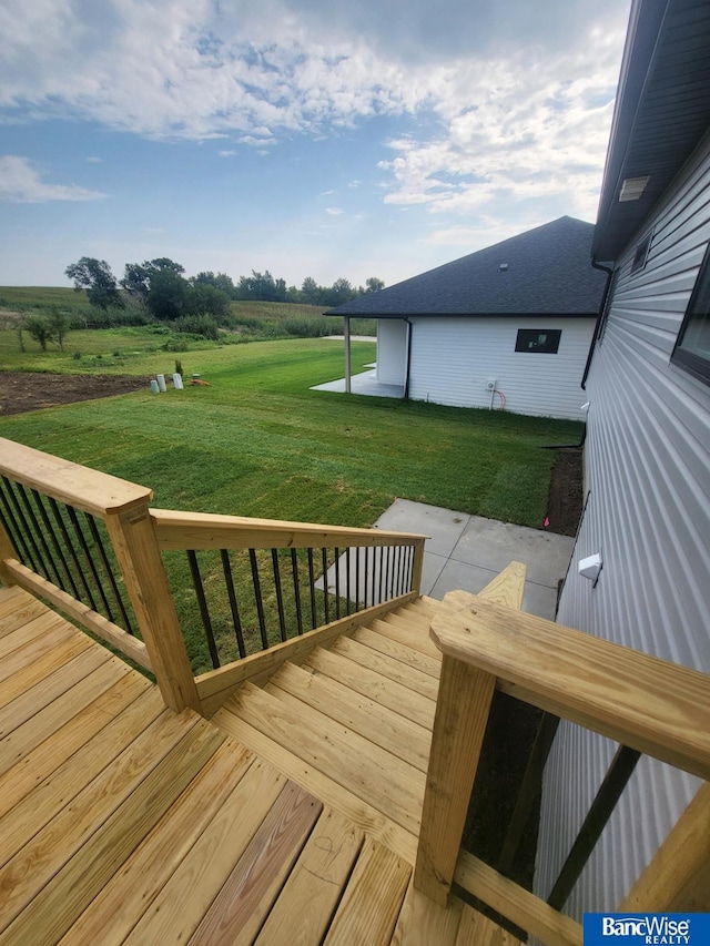 wooden deck with a patio and a lawn