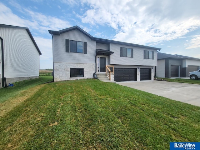 bi-level home featuring a garage and a front lawn