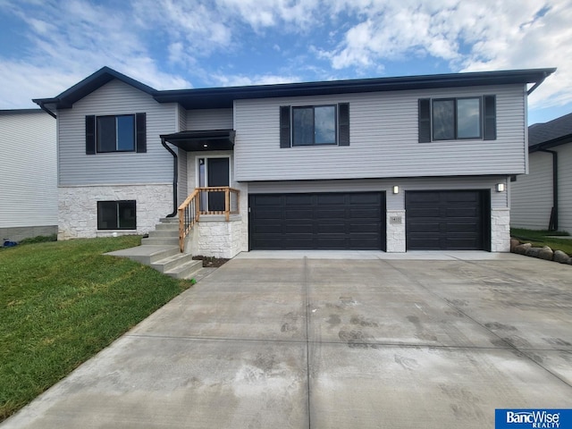 bi-level home featuring a garage and a front yard