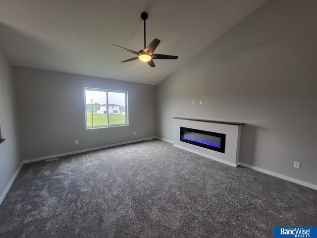 unfurnished living room featuring ceiling fan, lofted ceiling, and dark carpet