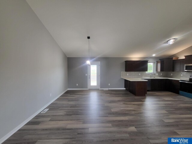 kitchen featuring tasteful backsplash, dark brown cabinets, dark wood-type flooring, and electric range