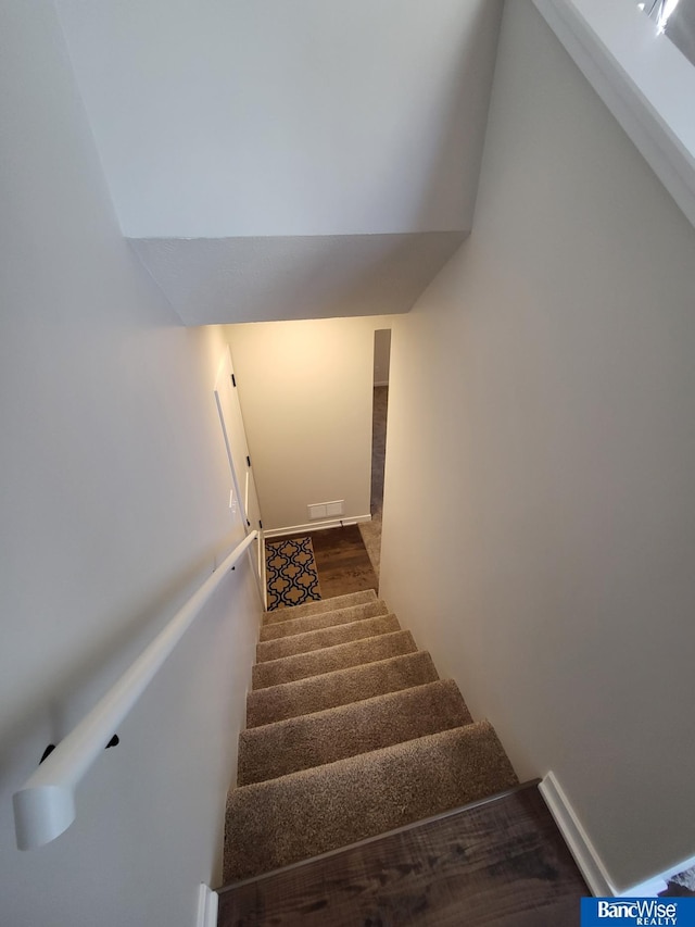 stairs featuring hardwood / wood-style floors