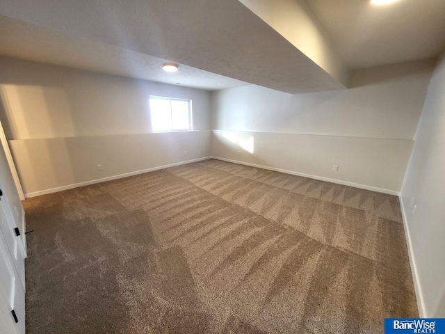 basement featuring carpet flooring and baseboards