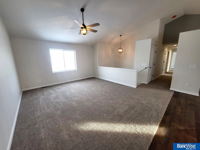 empty room featuring lofted ceiling, baseboards, dark colored carpet, and a ceiling fan