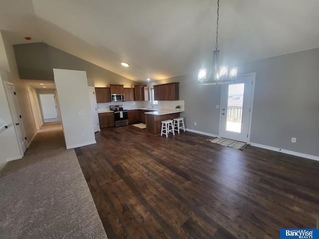 kitchen featuring a breakfast bar area, open floor plan, light countertops, appliances with stainless steel finishes, and a center island