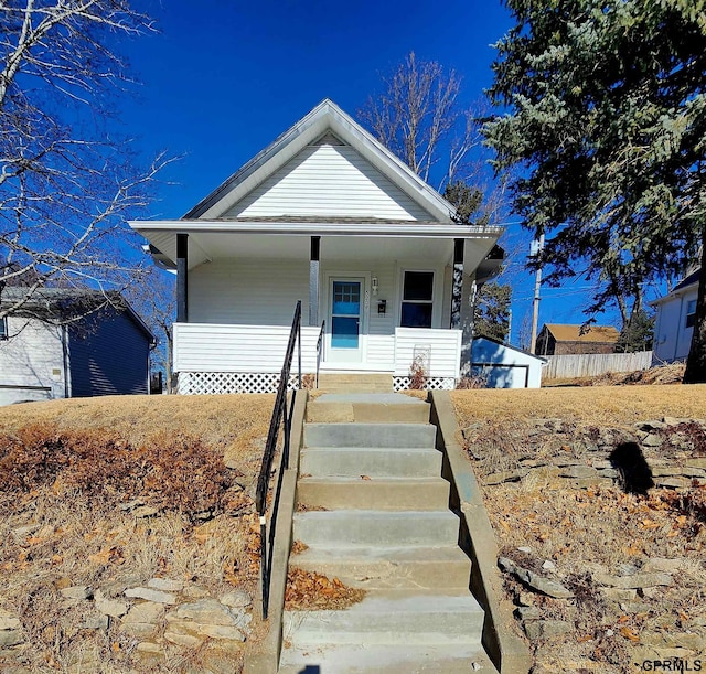 bungalow-style house with a garage, an outdoor structure, and covered porch