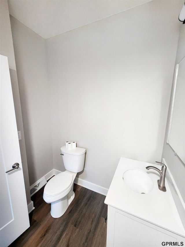 bathroom with hardwood / wood-style flooring, vanity, and toilet