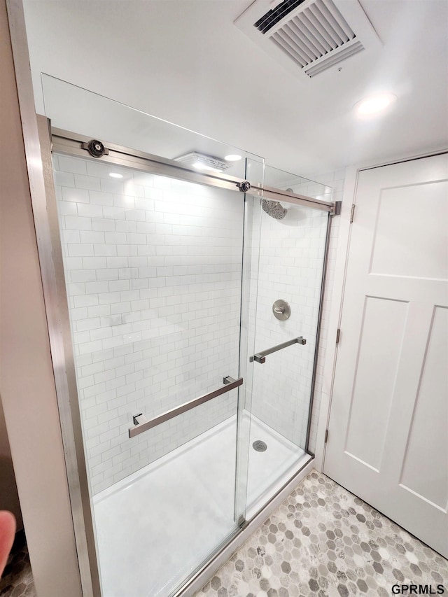 bathroom featuring a shower with door