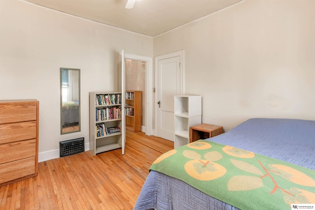 bedroom with baseboards, visible vents, ceiling fan, and wood finished floors