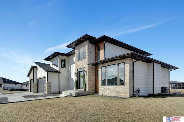 back of house with central AC unit, a garage, and a lawn