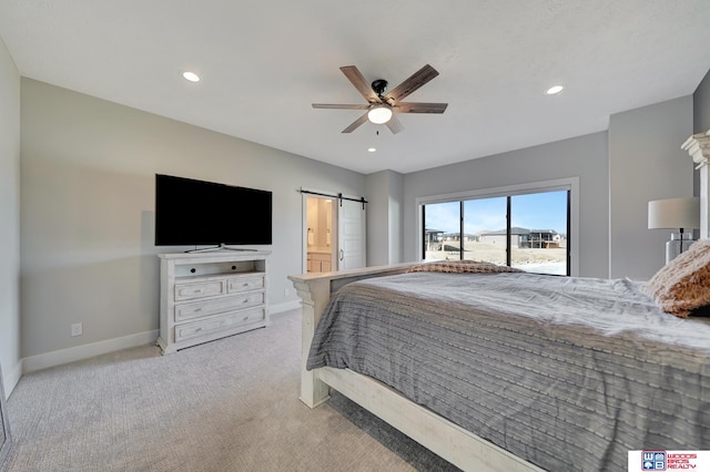 bedroom featuring light colored carpet, a barn door, and ceiling fan