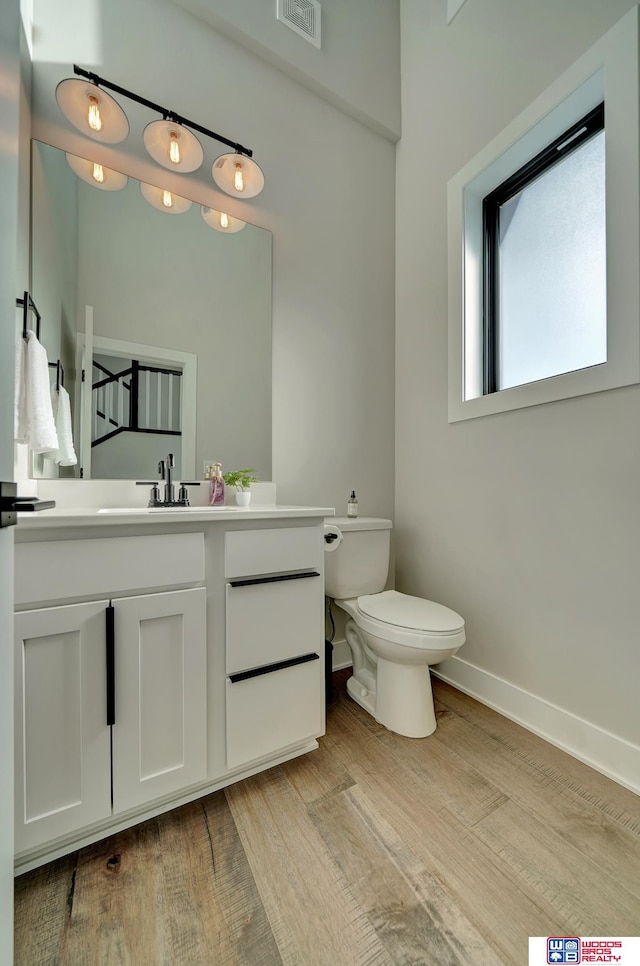 bathroom featuring vanity, wood-type flooring, and toilet