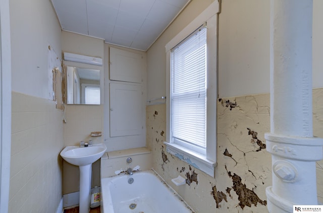 bathroom featuring sink, tile walls, and a tub